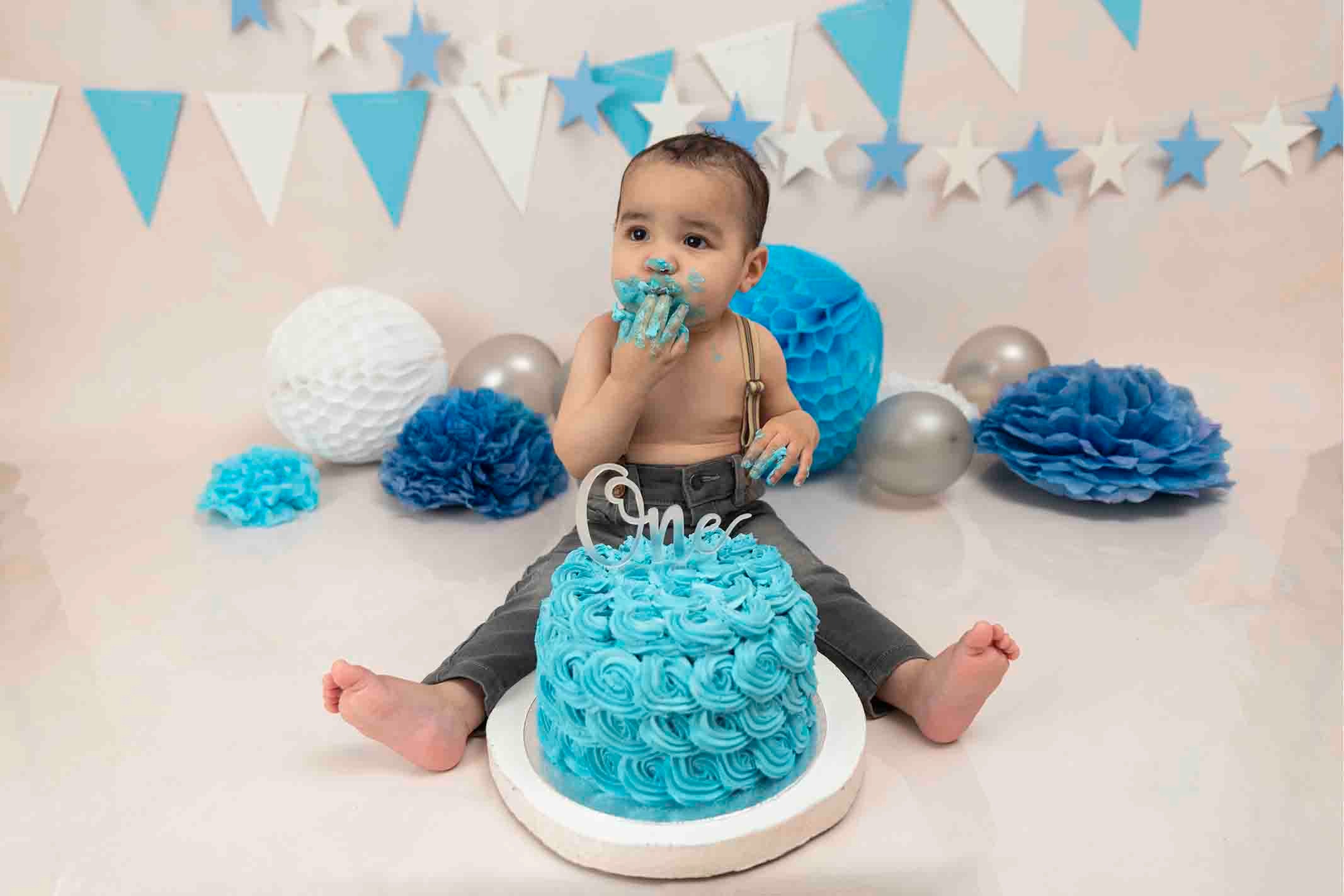 Cake smash photoshoot with boy tasting cake
