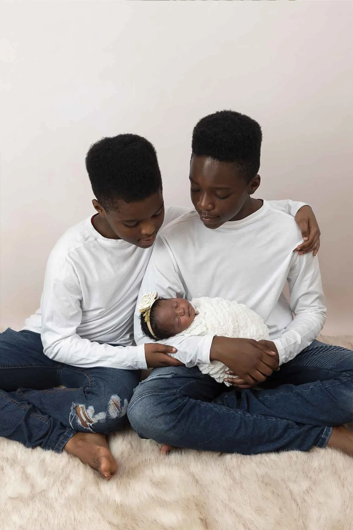 brothers holding newborn at photoshoot