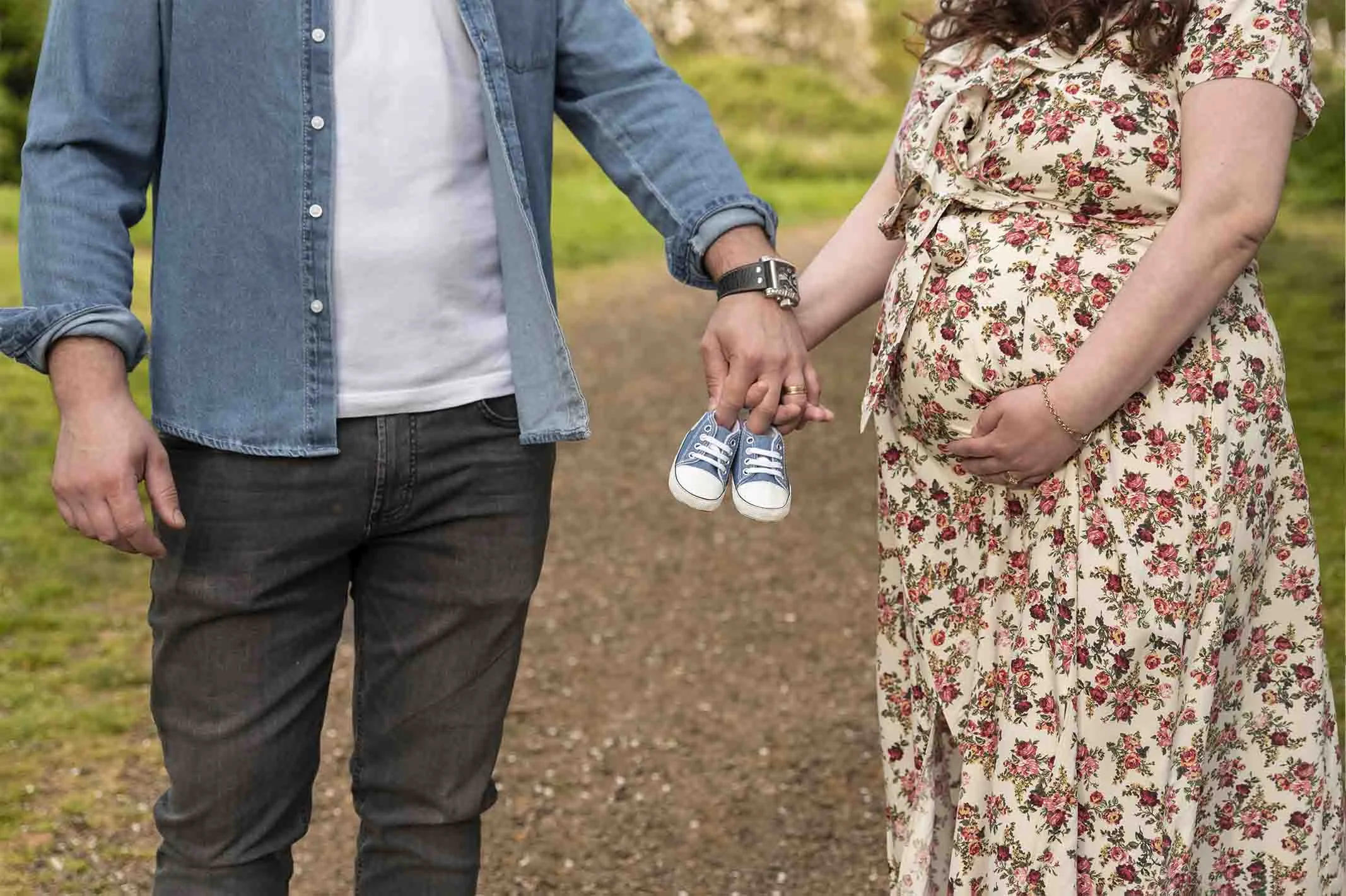 couple holding hands at maternity photoshoot outdoor
