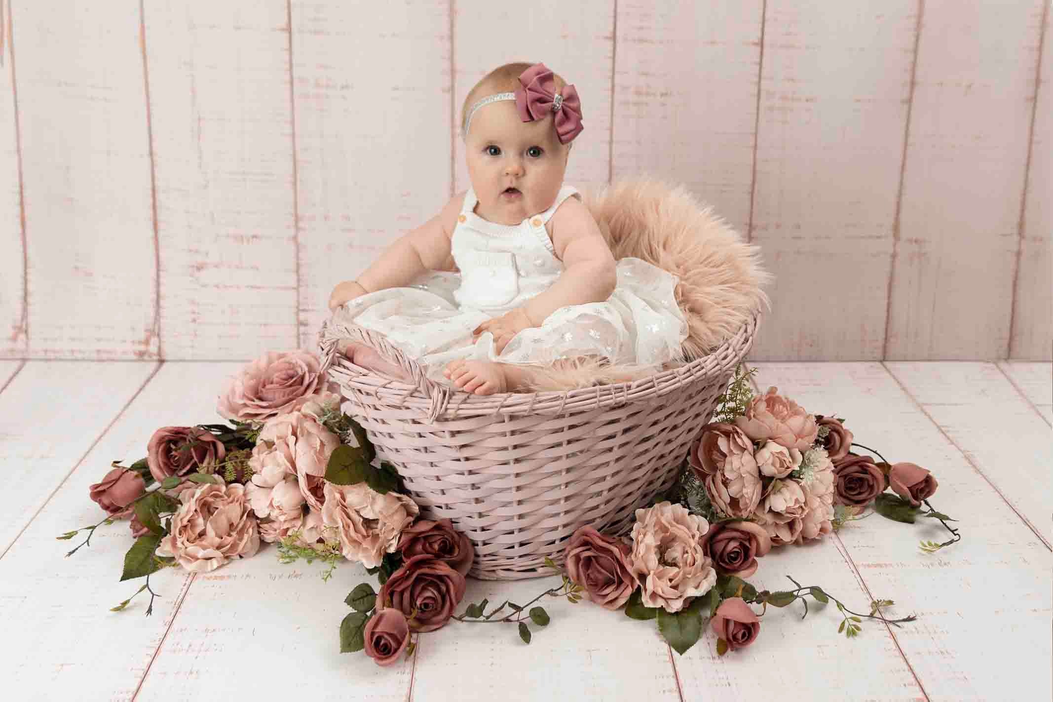 little girl in basket at baby photoshoot