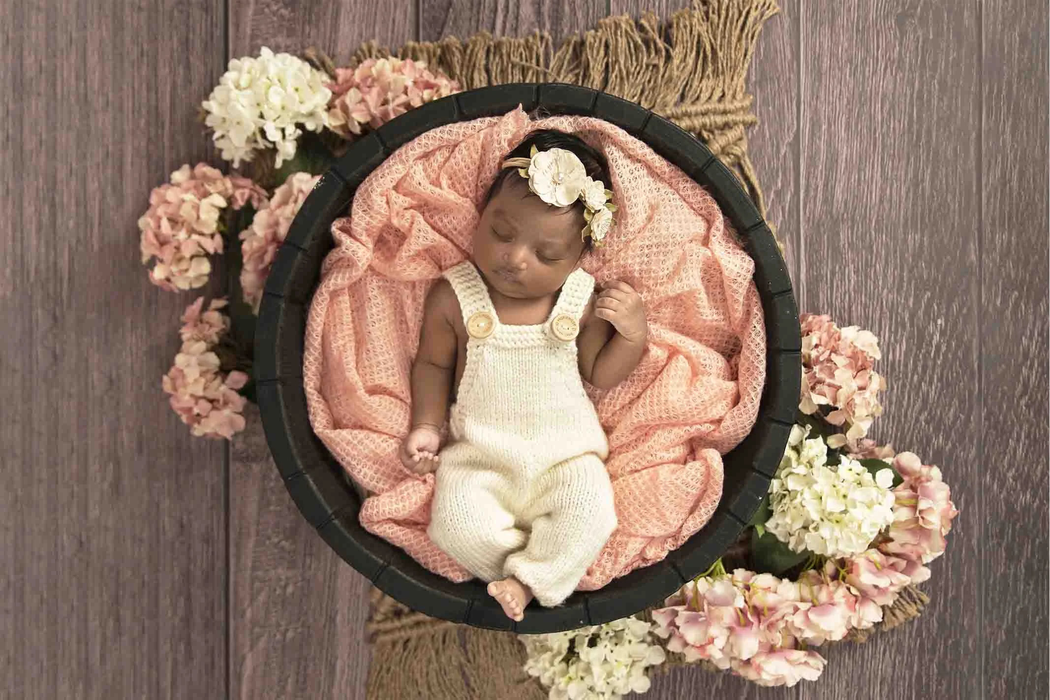 newborn in pink basket