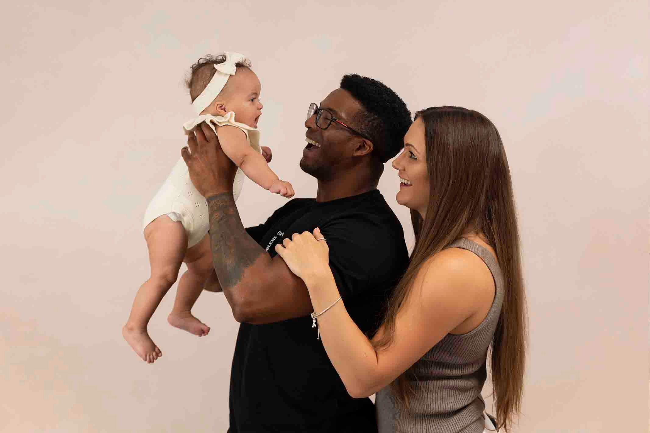 parents holding baby at photoshoot